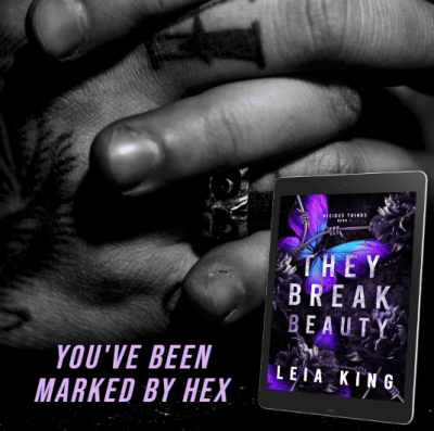 A close-up of tattooed hands clasped together, with an e-reader displaying the cover of 'They Break Beauty' by Leia King. The cover features a dark, floral design with purple accents. Text on the image reads 'You've Been Marked By Hex.